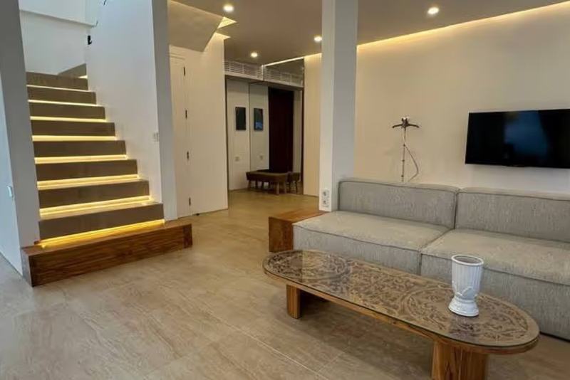 Ocean-view villa in Dreamland, Balangan: sofa and TV next to the stairs