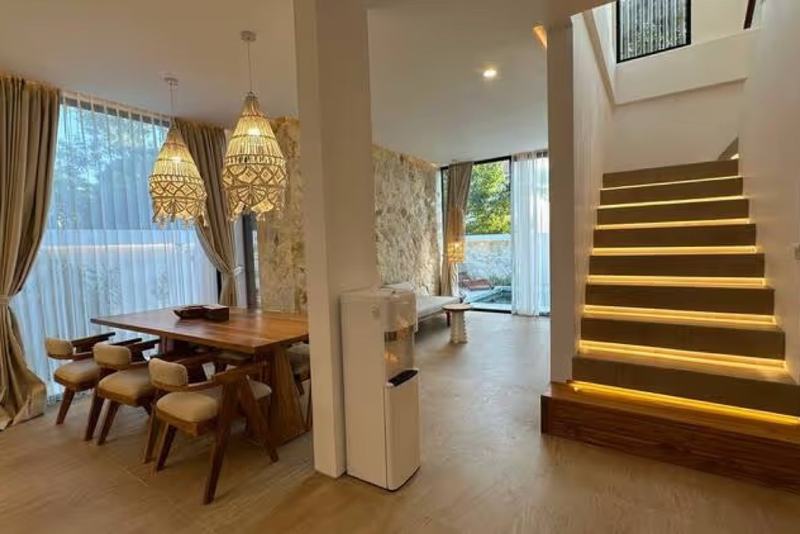 Ocean-view villa in Dreamland, Balangan: wooden dining table under woven pendant lamps