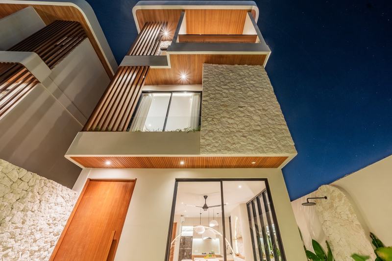 Split-level villa near Balangan: stone and timber facade lit at dusk