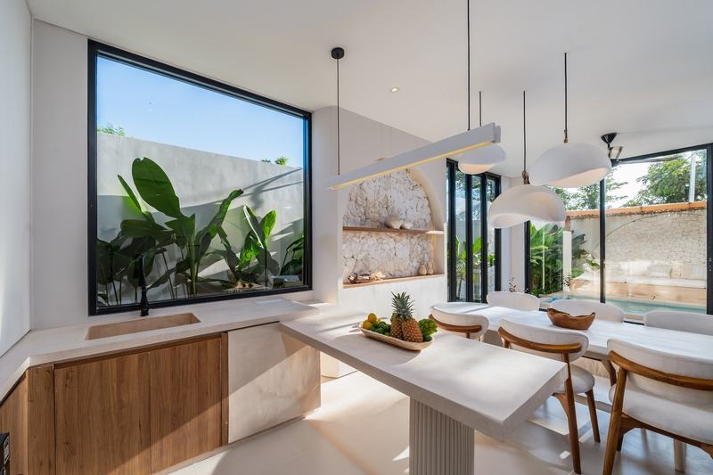Split-level villa near Balangan: island kitchen and a dining table by the courtyard window