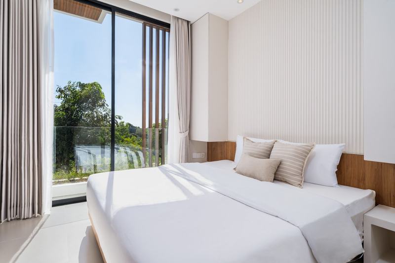 Split-level villa near Balangan: bedroom opening onto a balcony among the treetops