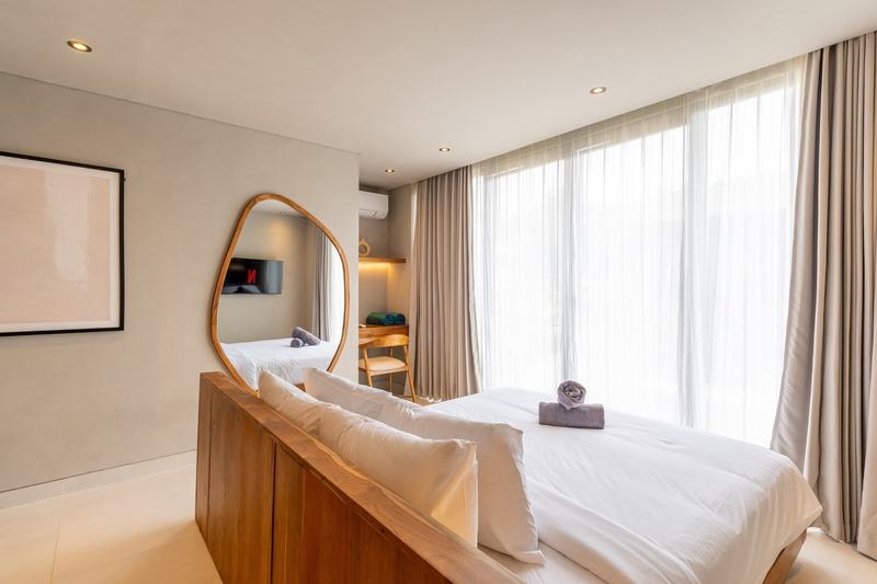 Two-level villa in Bingin: bedroom with a tall window and mirror