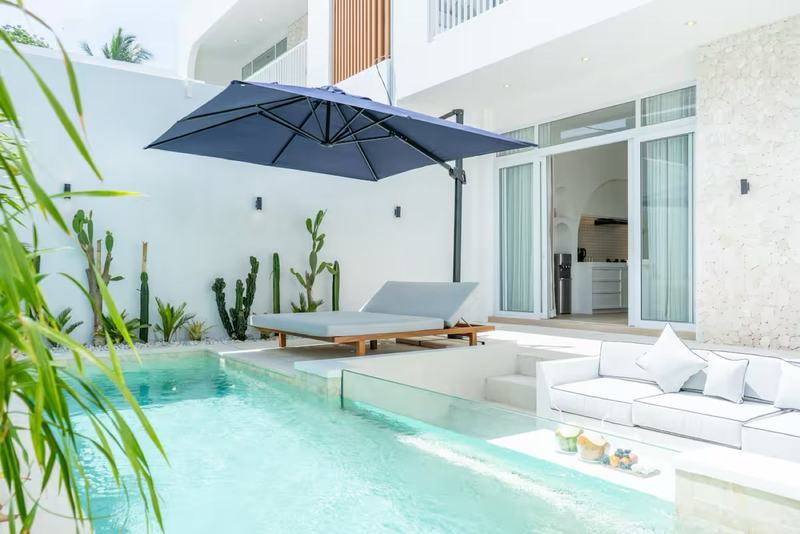 Open-plan villa in Bingin: pool and shaded lounger by the glass wall