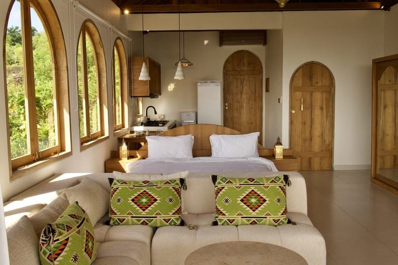 Villa en la colina de Bingin: dormitorio con ventanas en arco y alfombras