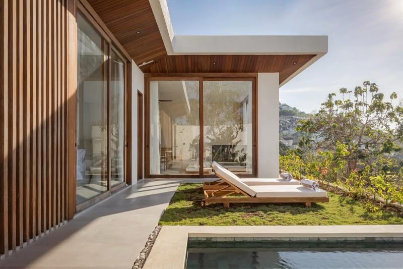 Sunset-view villa in Bingin: sun lounger by the pool, hills beyond