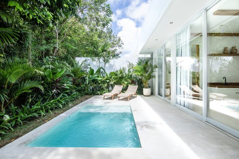 Garden villa in Bingin: pool along the glass facade among greenery