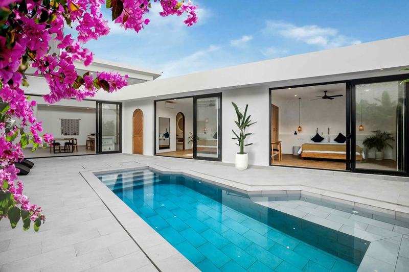 Three-bedroom villa in Bingin: pool courtyard and facade with arched doors