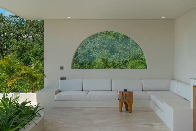 Three-bedroom villa in Bingin: lounge with an arched window onto greenery
