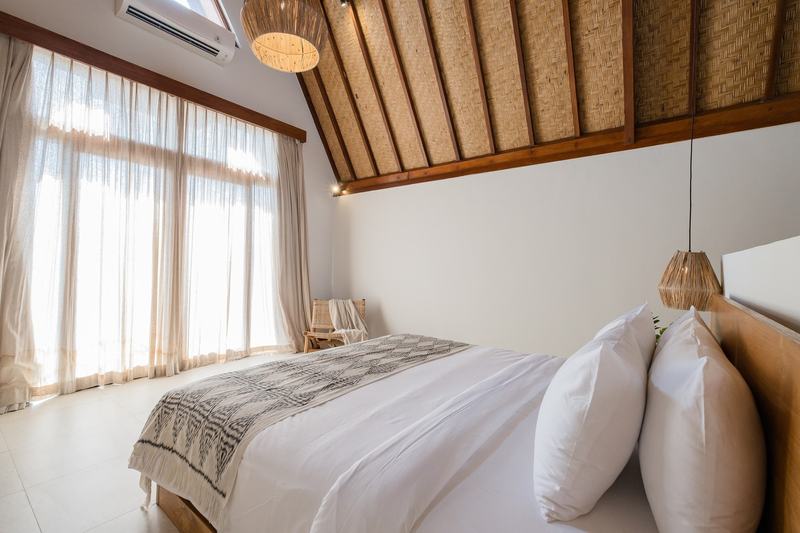 Three-bedroom villa with a wooden deck in Bingin: bedroom under a thatched roof