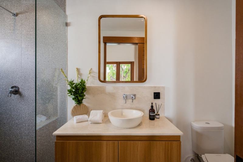 Three-bedroom villa with a wooden deck in Bingin: bathroom with a wood-framed mirror