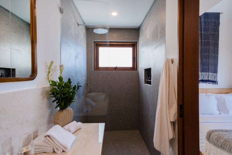Three-bedroom villa with a wooden deck in Bingin: shower with stone walls