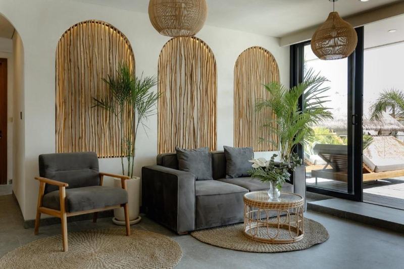 Berawa one-bedroom apartment: entrance lounge with sofas and rattan arches
