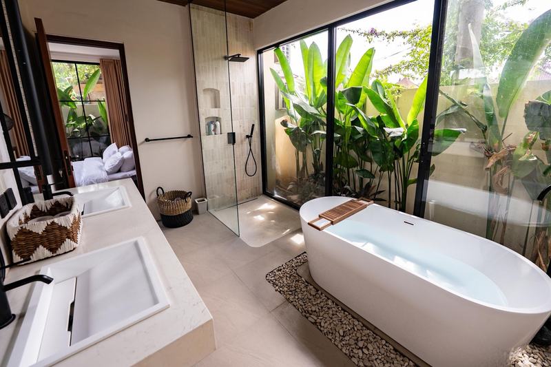Central Canggu three-bedroom villa: freestanding tub by a garden window