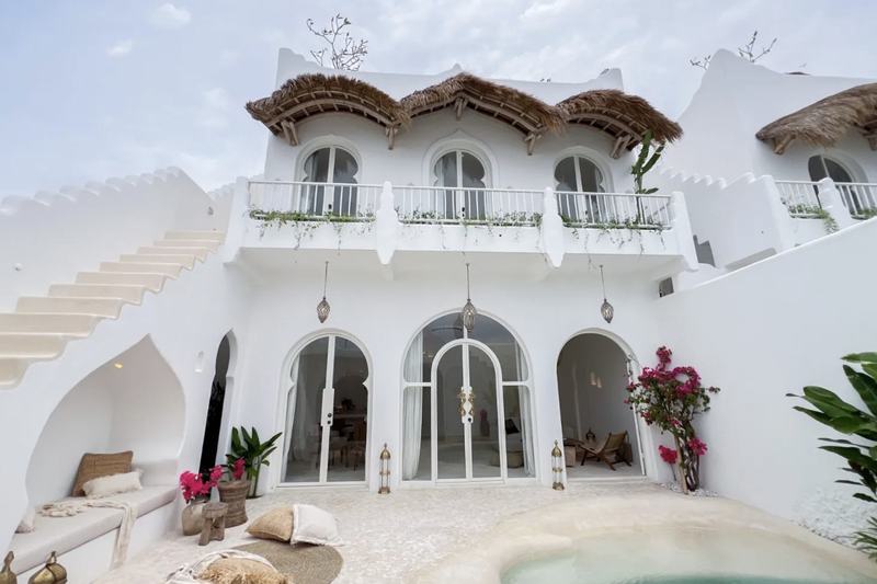 Casa Kayana: white villa front with arches and reed awnings