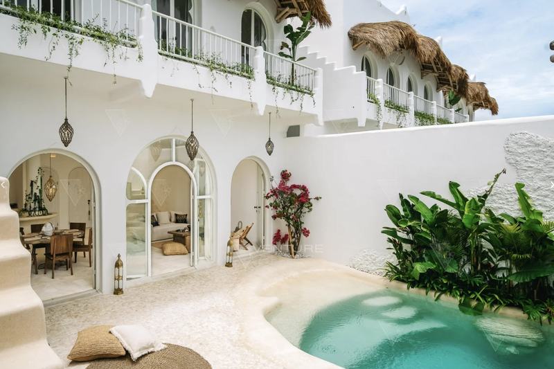 Casa Kayana: pool courtyard framed by arched windows