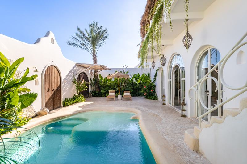 Casa Nostra: courtyard pool and white facade with arched doors