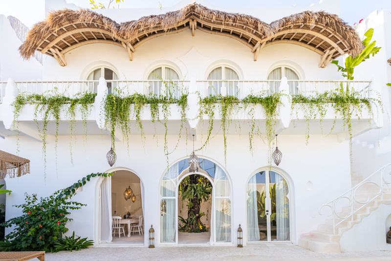 Casa Nostra: fachada de la villa con balcones bajo cubierta de paja