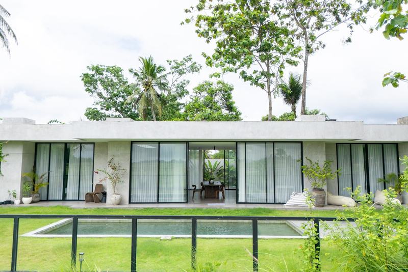 Four-bedroom villa near Cemagi: long glazed facade and a pool on the lawn