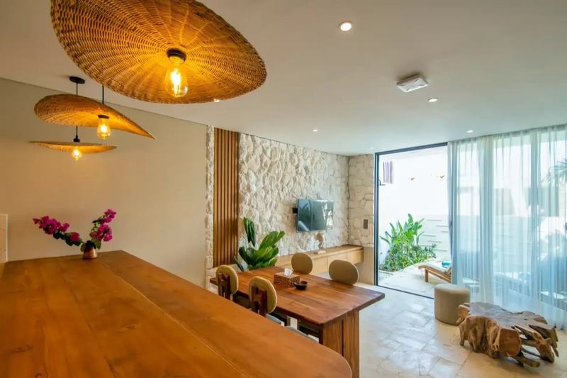 Two-bedroom villa in Melasti: living and dining room with a stone wall