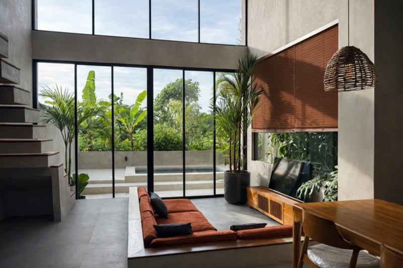 Loft villa near Nyang Nyang: living room behind a glass wall, with the garden and plunge pool outside