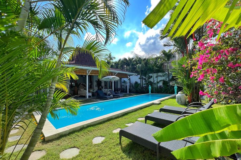 Four-bedroom villa in Seminyak: garden with the pool and sun loungers