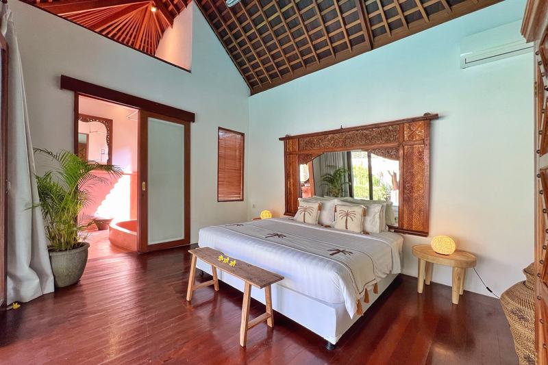 Six-bedroom villa in Seminyak: bedroom with a carved mirror