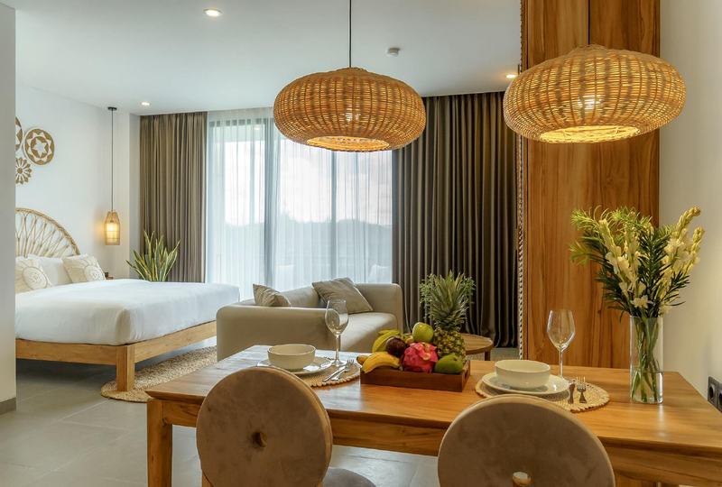 Sunny Aparts I: studio with dining table, sofa and bed by a picture window, developer photo
