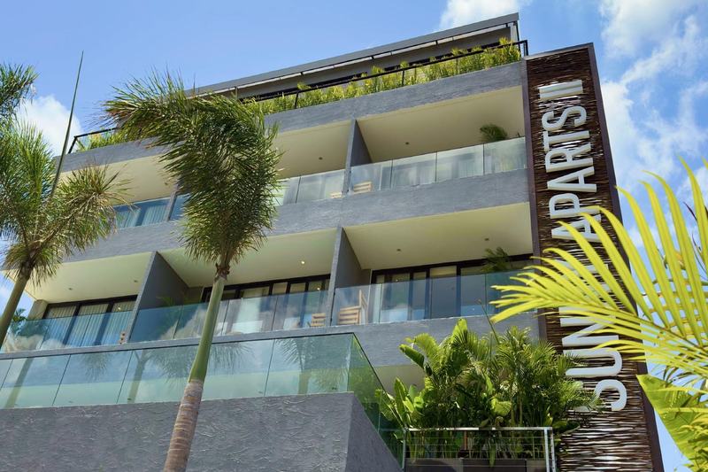 Sunny Aparts II: four-story facade with balconies and palms, developer photo
