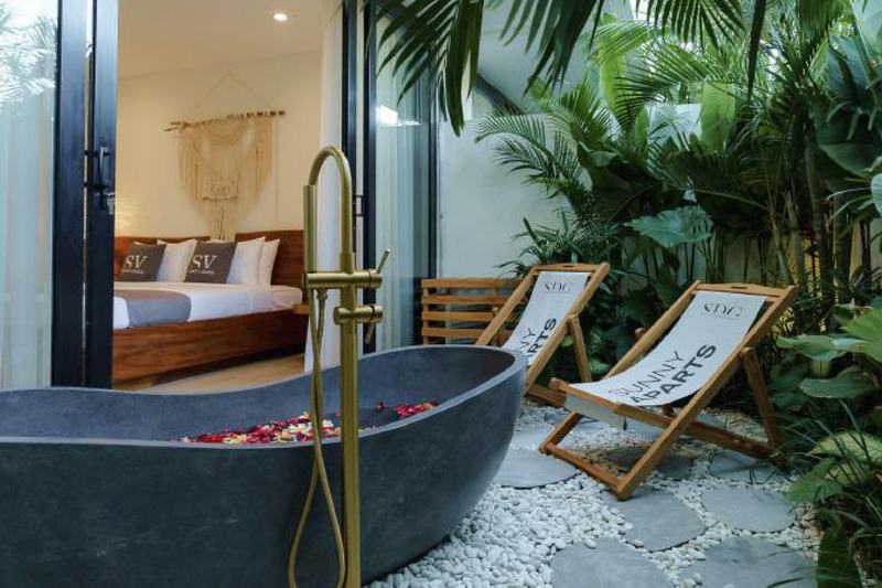 Sunny Aparts II: stone bathtub in a planted courtyard, developer photo