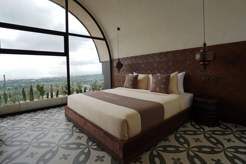 Sunny Samudra: studio bed facing a full-height arched window