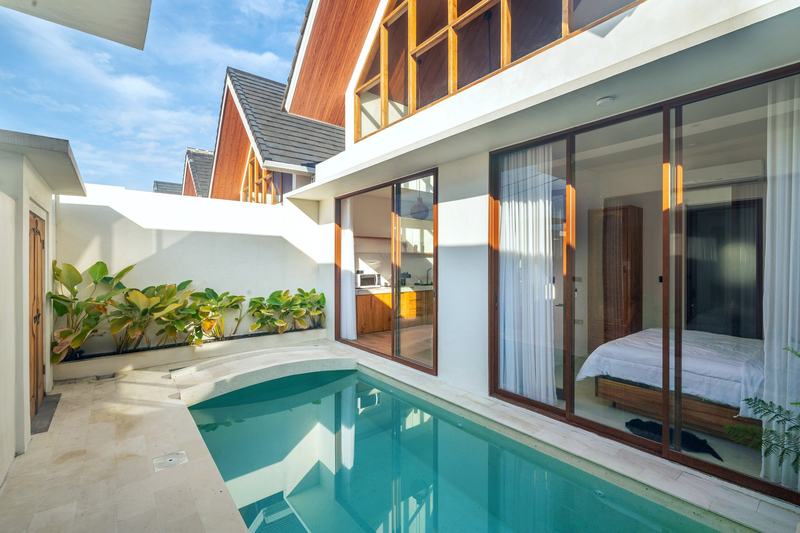 Sunset Village: courtyard pool with a bedroom behind glass doors, developer photo