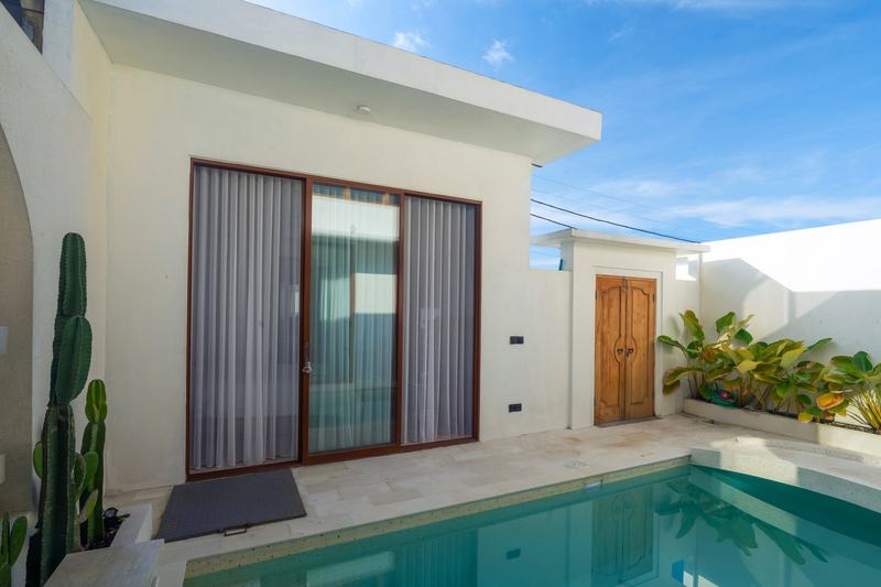 Sunset Village: pool, living room exit and a carved front door, developer photo