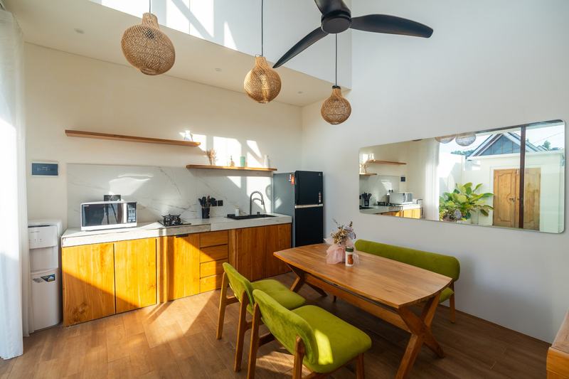 Sunset Village: double-height kitchen and living room with dining table and ceiling fan, developer photo