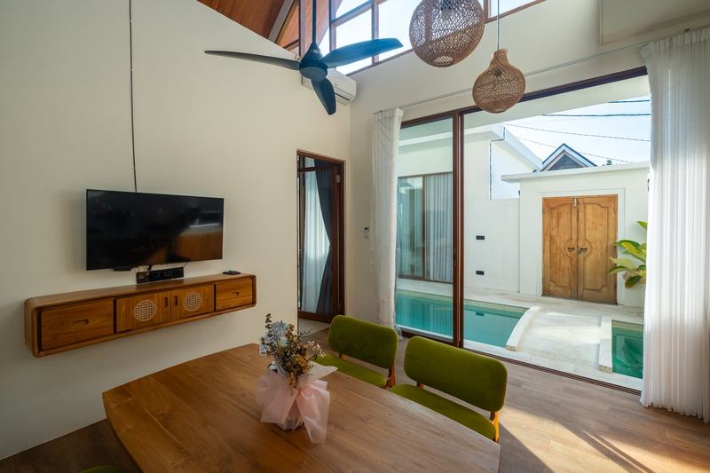 Sunset Village: dining area with a TV and sliding doors to the pool, developer photo
