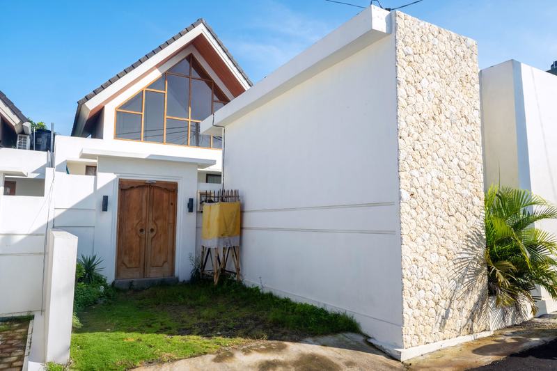 Sunset Village: villa entrance with a carved wooden door under a gabled roof, developer photo