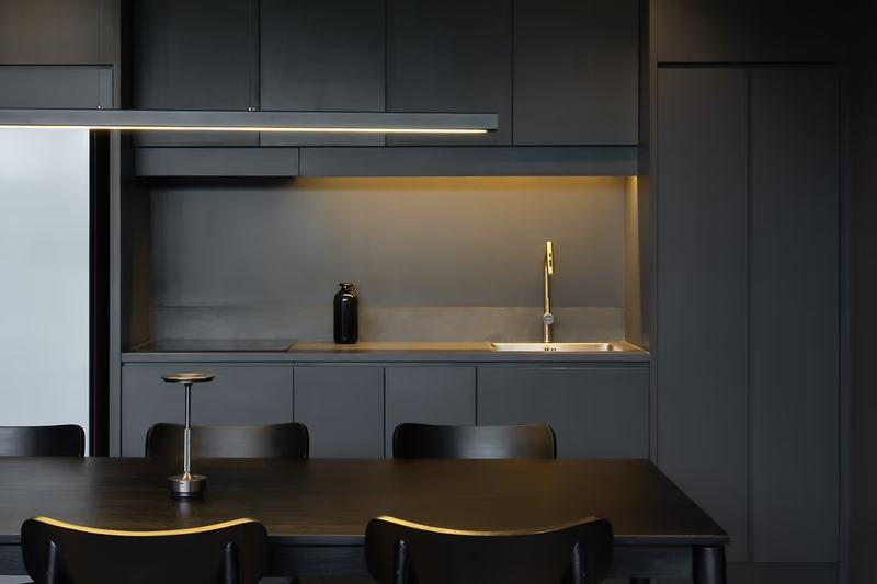 The Grey House: cocina con electrodomésticos integrados y encimera iluminada
