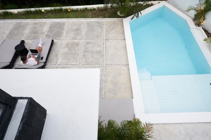 Two-story villa in Ubud: pool and paved courtyard with loungers, seen from above