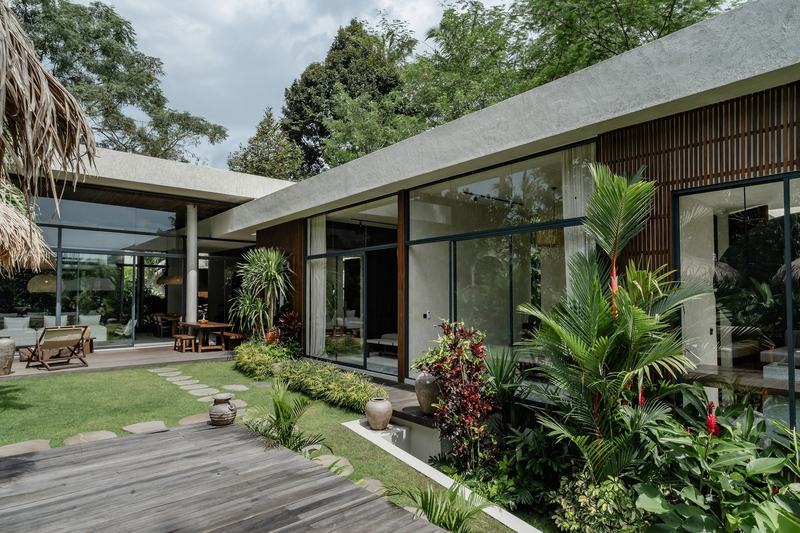 Three-bedroom villa north of Ubud: single-story glass house behind a lawn