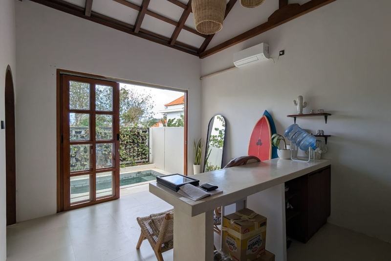 One-bedroom villa in east Uluwatu: living room with a kitchen counter and doors to the pool