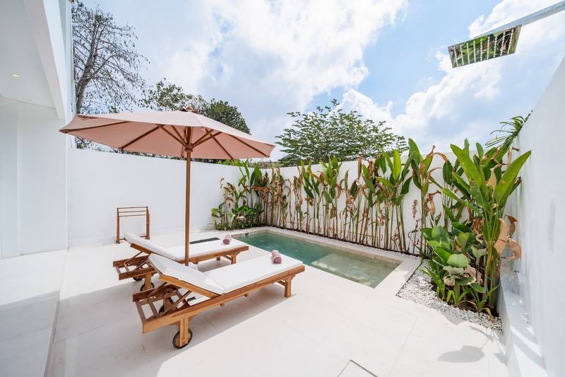 Mediterranean-style villa in Ungasan: pool, loungers and umbrella by a planted wall