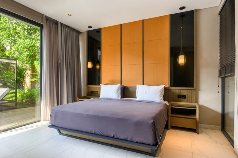Three-bedroom villa near GWK: bedroom with a timber wall