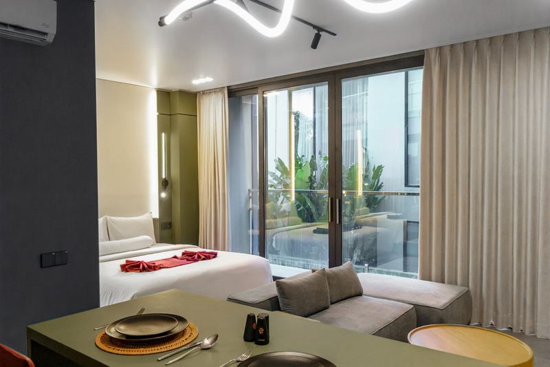 XO Canggu studio: kitchen island, bed and the way out to the balcony
