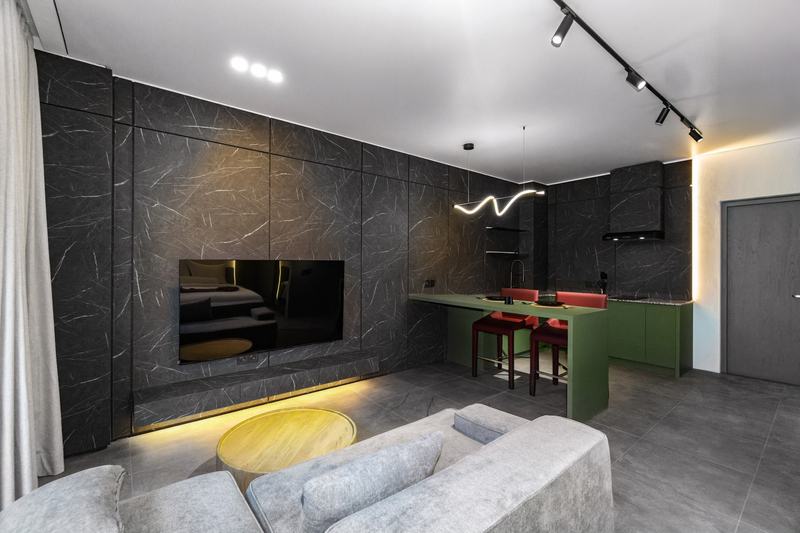 XO Canggu: studio lounge corner with dark stone and a green kitchen