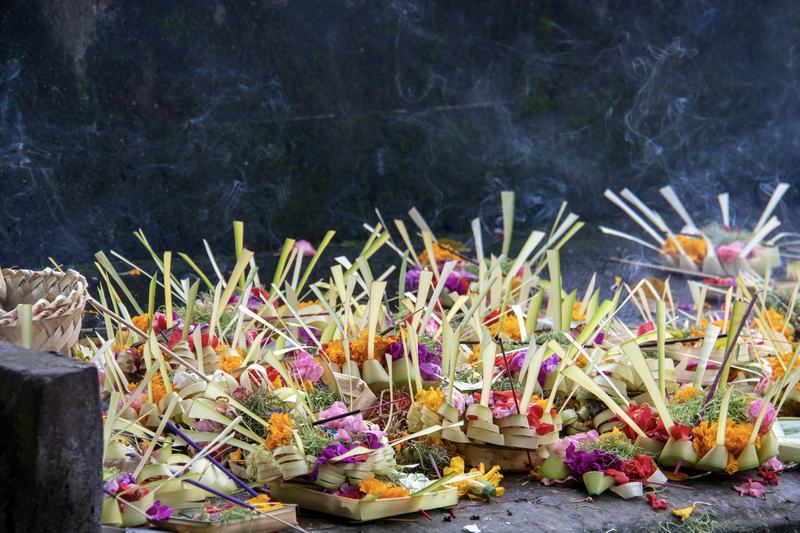 Rangées d'offrandes cérémonielles balinaises disposées sur une plateforme en pierre