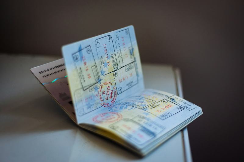 An open passport with entry stamps on a table
