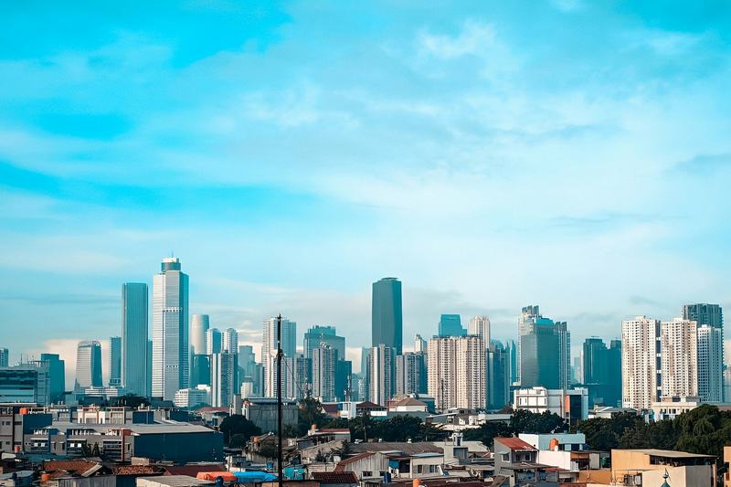 Office towers in Jakarta's business district under a blue sky