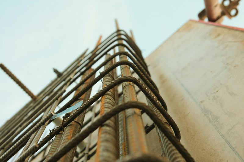 Cage d'armatures en acier d'un poteau en béton sur un chantier de Bali, vue d'en bas, sur fond de ciel