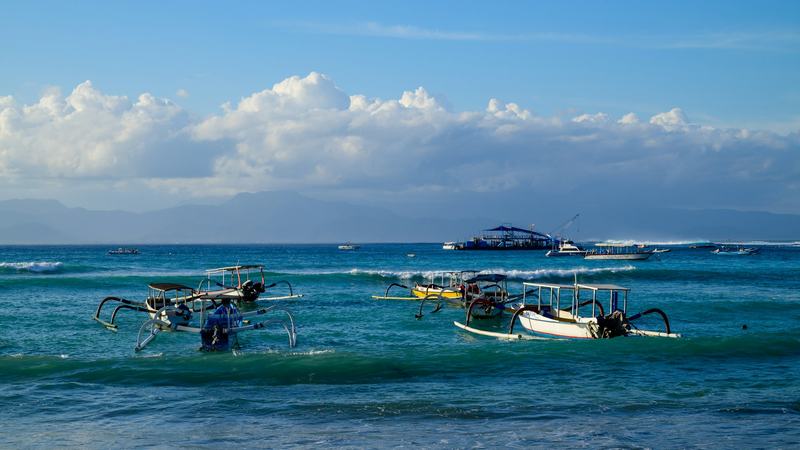 Bateaux traditionnels jukung sur une eau turquoise au large de Nusa Lembongan