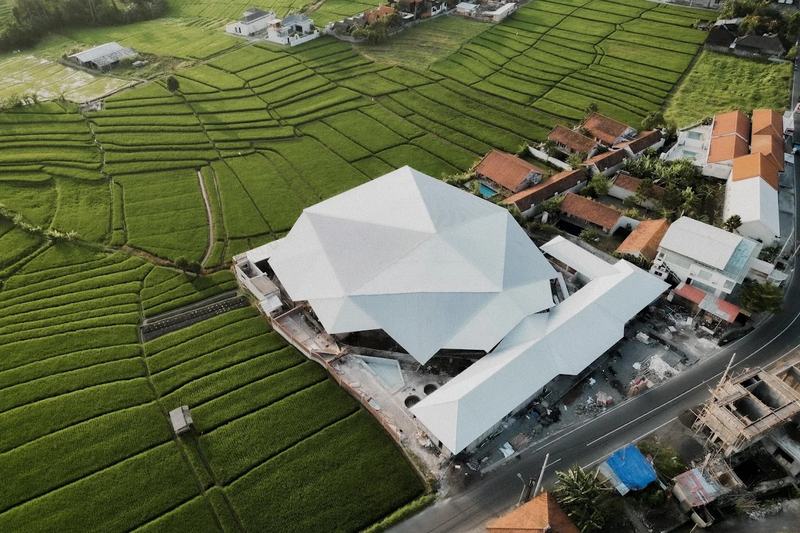 Aerial view of a roofed padel club among rice fields in Bali