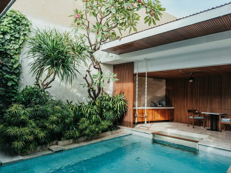 Courtyard pool of a villa with a covered terrace and tropical plants